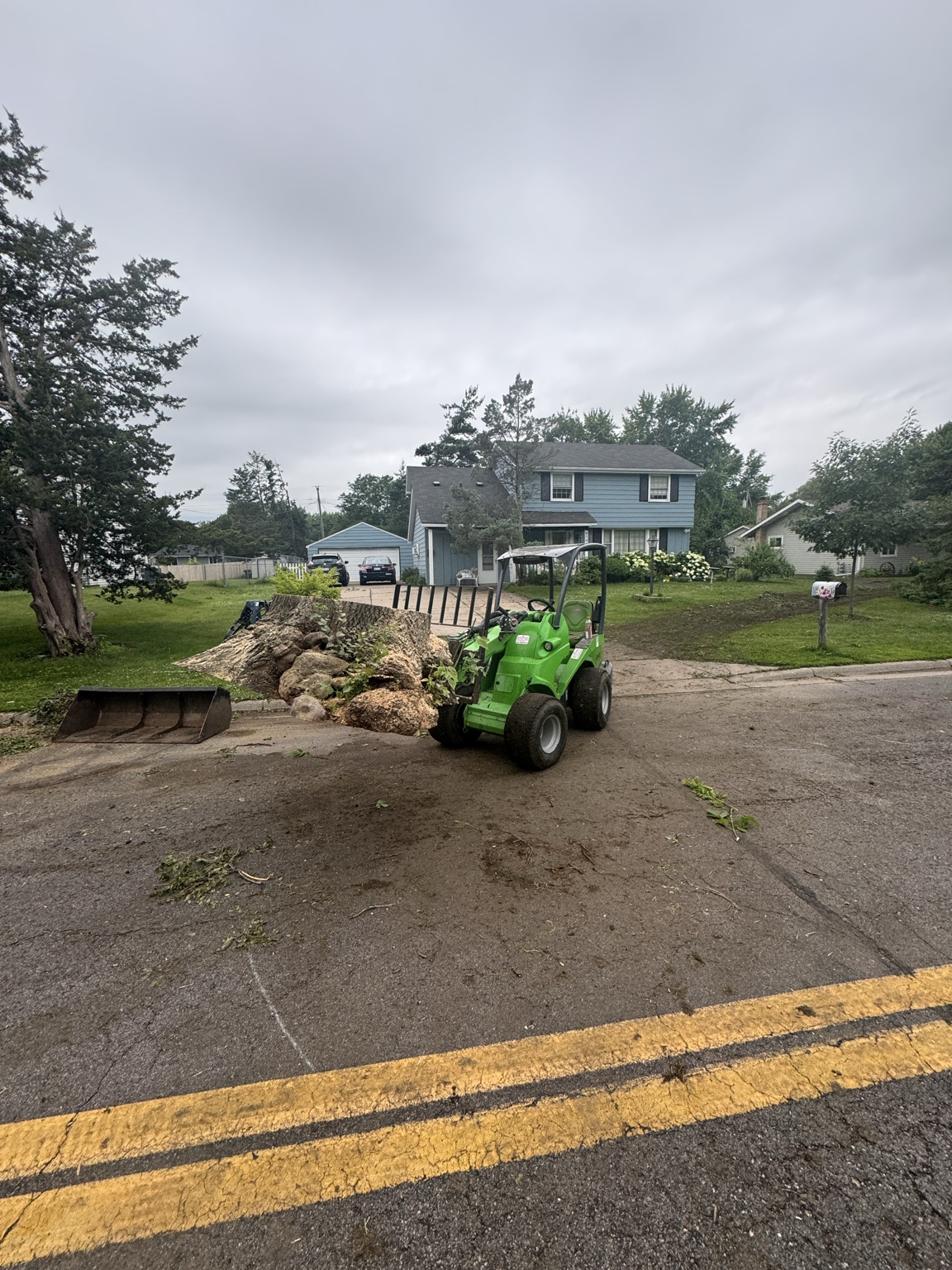 Loader cleaning up brush near a chip truck